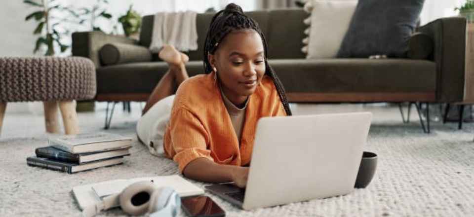 black woman laying on floor with laptop